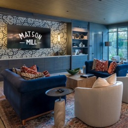 a clubroom with a couch, table and chairs