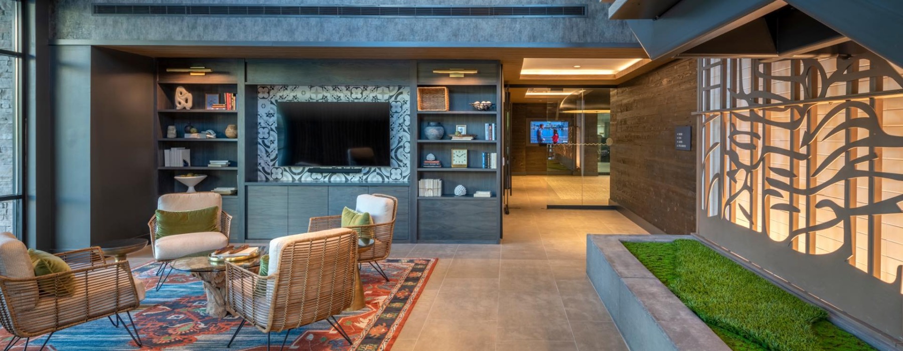 a lounge with a tv, chairs and a table